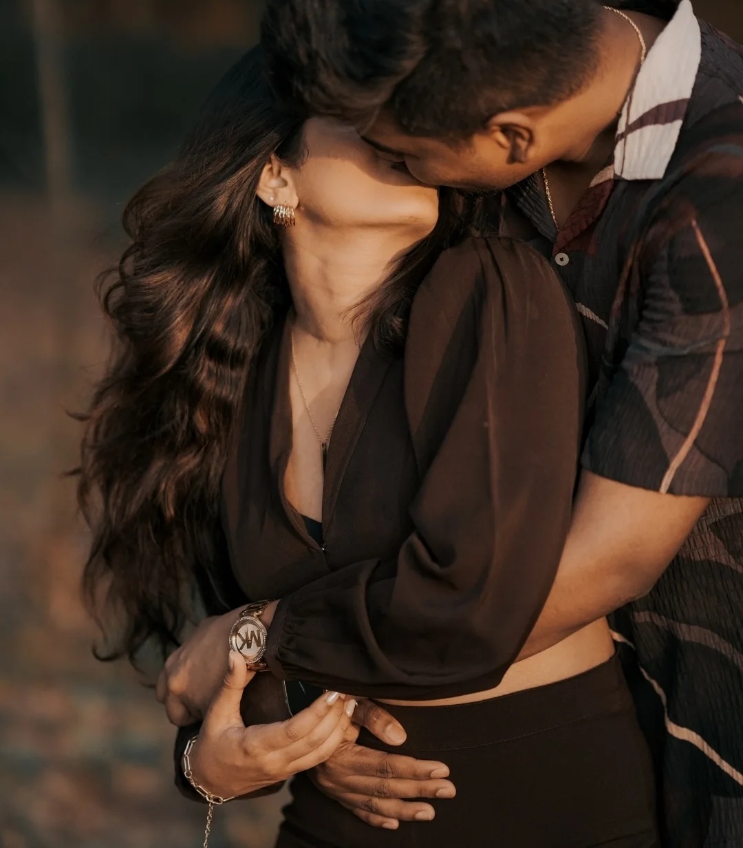 A couple embracing beside a carved wooden staircase